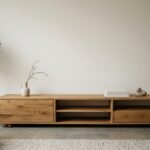 Ein niedriges Lowboard aus massivem Holz lässt die Wand darüber frei und beruhigt den Raum.